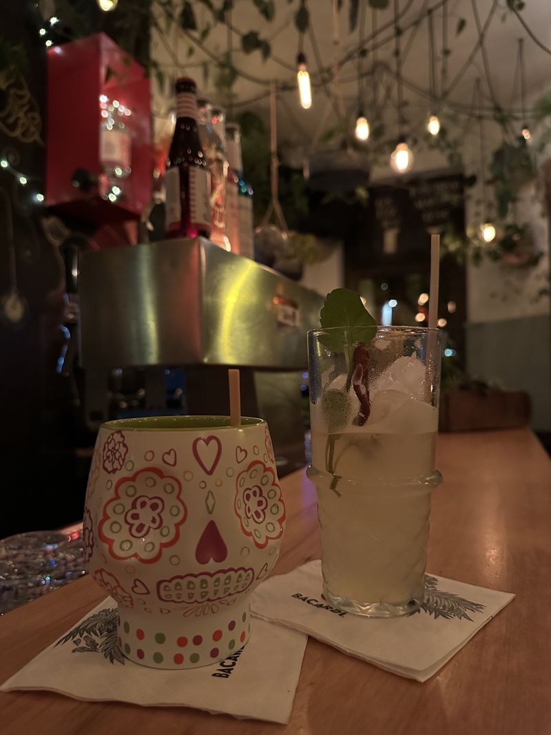 Zwei Cocktails auf dem Tresen, einer im bunt bemalten Totenkopfbecher